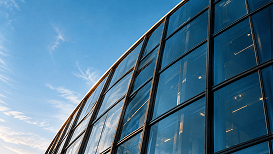 Curved glass building against a blue sky