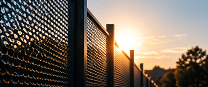 Perforated metal fence at sunset